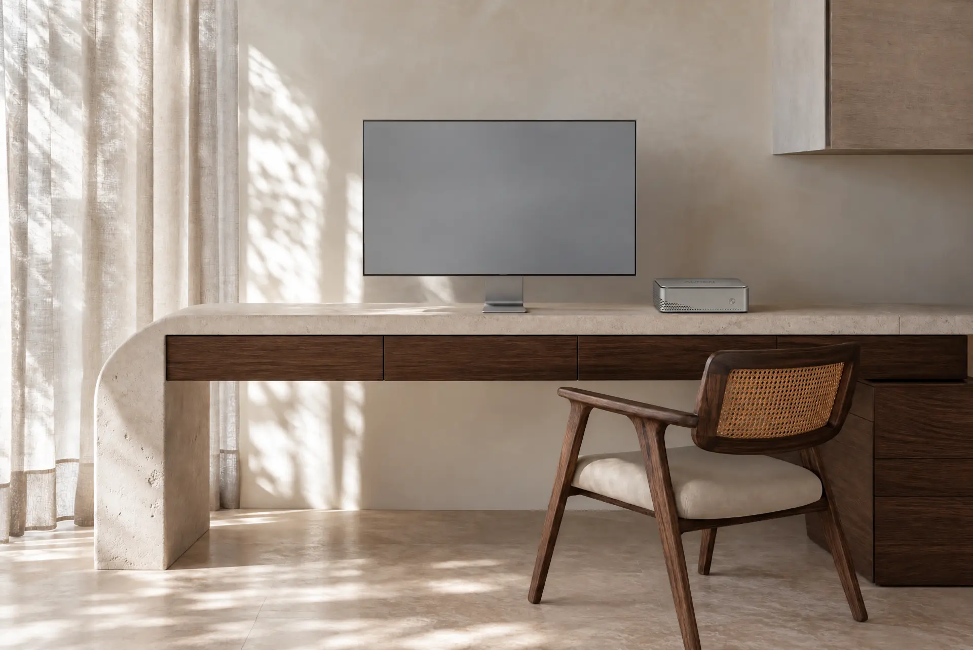 Auren One on a limestone and walnut desk beside a thin monitor in a sunlit room